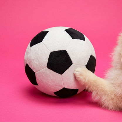 Plush soccer ball dog toy with puppy paw on pink background
